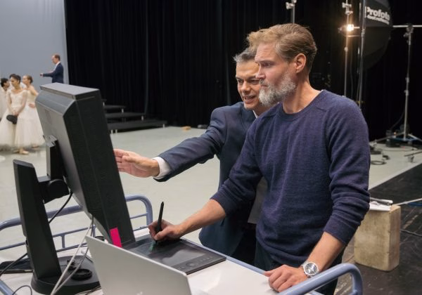 Kaksi henkilöä työskentelemässä tietokoneen ääressä.