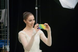 Balettitanssija ottamassa valokuvaa toisista tanssijoista kännykällään.